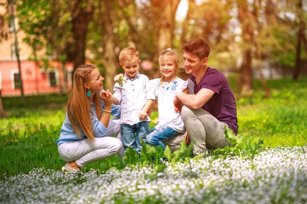 Retrato de la familia divirtiéndose en el parque de la ciudad floreciente — Foto de Stock