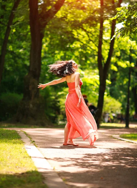 Vrolijke jonge vrouw geniet van dansen in het groene stadspark op de natuur — Stockfoto