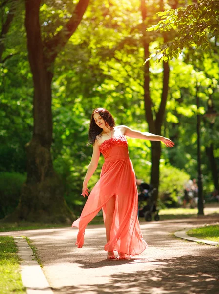 Joyful young woman enjoys dancing in green city park on nature — Stock Photo, Image