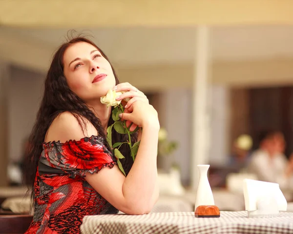 Menina de vestido sentado à mesa no restaurante e desfrutar de aroma — Fotografia de Stock