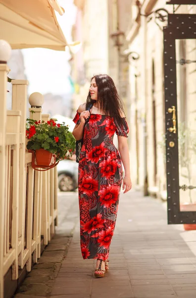 Joyful lady woman in long beautiful dress walking along street