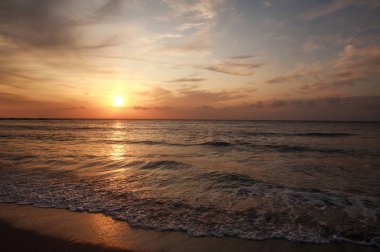Gökyüzü ve bulutlar arka plan üzerinde deniz kıyısında renkli gün batımı