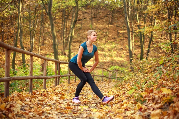 Młoda szczupła kobieta robi ćwiczenia fitness rozciągające się jesienią — Zdjęcie stockowe