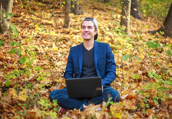 Mladý muž podnikatel v klasické modré bundě s notebookem sezení — Stock fotografie