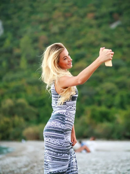 魅力的な女の子は緑の山々 Ciraliビーチ トルコ ヨーロッパを背景に海によってスマートフォンで自撮り — ストック写真