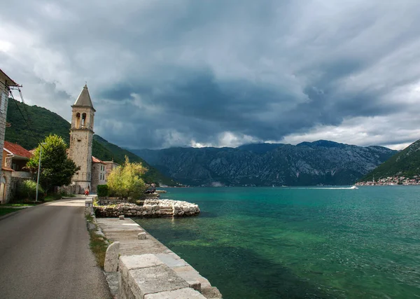 Old town settlement around the lake, Kotor Bay, on the background of blue sky and clouds, Montenegro, Europe
