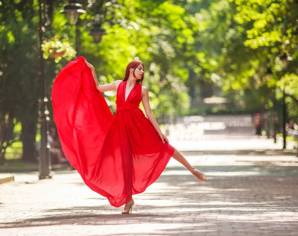 Молодая Женщина Роскошном Длинном Красном Платье Танцует Прыгает Городском Парке — стоковое фото