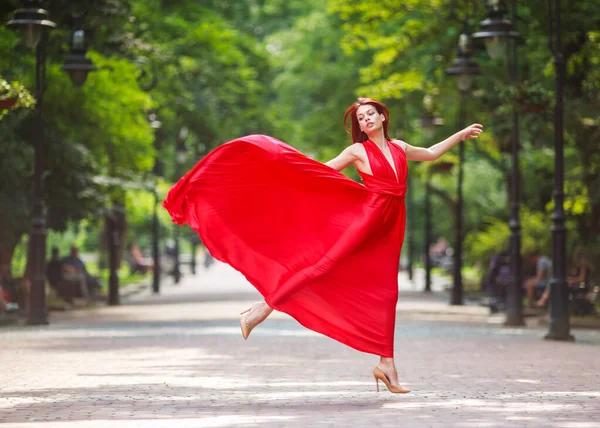 Молодая Женщина Роскошном Длинном Красном Платье Танцует Прыгает Городском Парке — стоковое фото