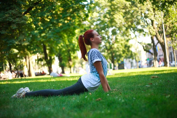 若いです女性女の子で都市公園で緑の草ありますストレッチフィットネス演習屋外 — ストック写真