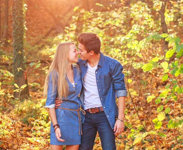 秋の森の中の幸せな抱擁で一緒に愛の若いカップル 夕日の光線で — ストック写真