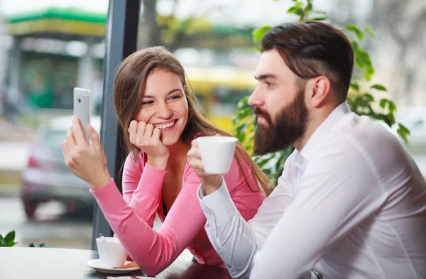 スマートフォンのあるカフェで幸せと愛情のカップル 楽しいコミュニケーションを持っている — ストック写真