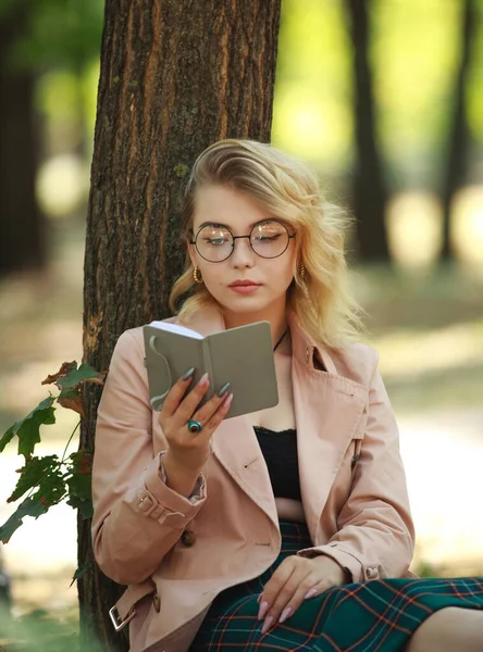 森公園の若い現代の女の子学生はノートを読みます — ストック写真