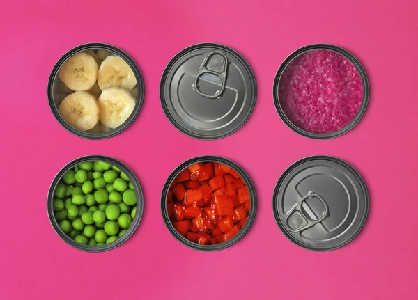 The concept of food in metal containers, canned food, red background ...