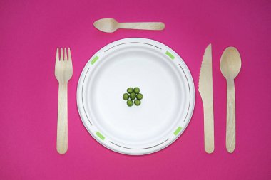 Üst görünümü, beyaz bir kağıt tabak, ekolojik ahşap tabak üzerinde yemek diyet ...