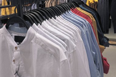 Büyük bir mağazada askıda erkek gömlek sırası, hipermarkette alışveriş ... 
