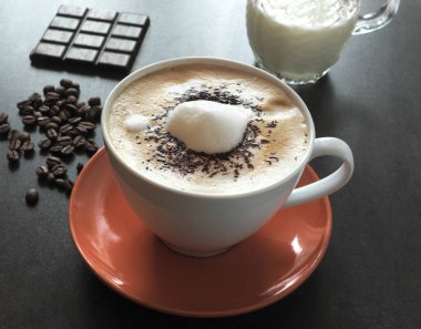 Sütlü kahve, çikolata ve krema serpilmiş. ...