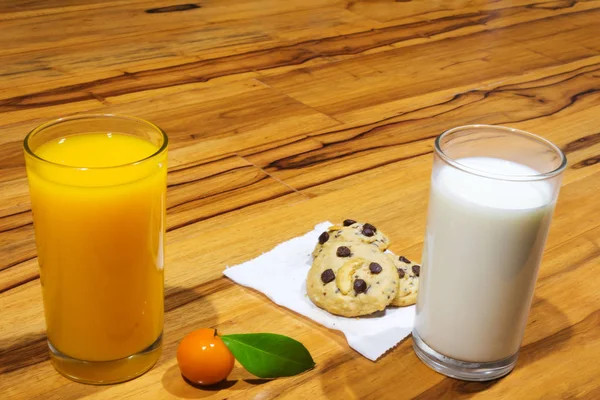 Zumo de naranja. postre de naranja. leche y galletas. sobre mesa de madera —  Fotos de Stock