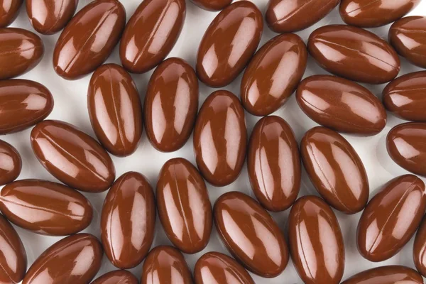 Vitamina E. alimentos complementarios. cápsula de color marrón. aislado en —  Fotos de Stock