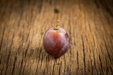 ahşap masa üstünde kırmızı üzüm 