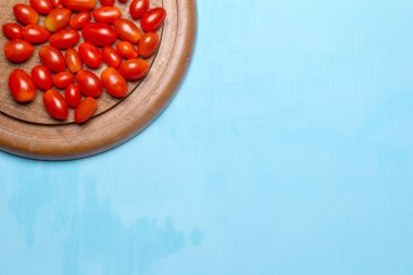 bebek domates. Erik. kiraz domates. Ahşap doğrama kurulu. üzerinde