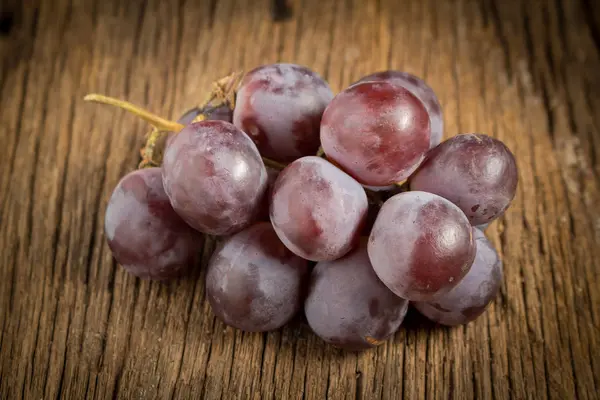 Красный виноград на деревянном столе — стоковое фото