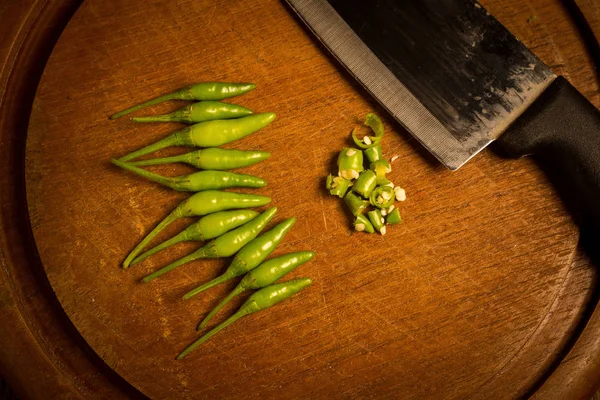 Madera redonda Corte de tabla de cortar. chiles verdes y rojos . — Foto de Stock