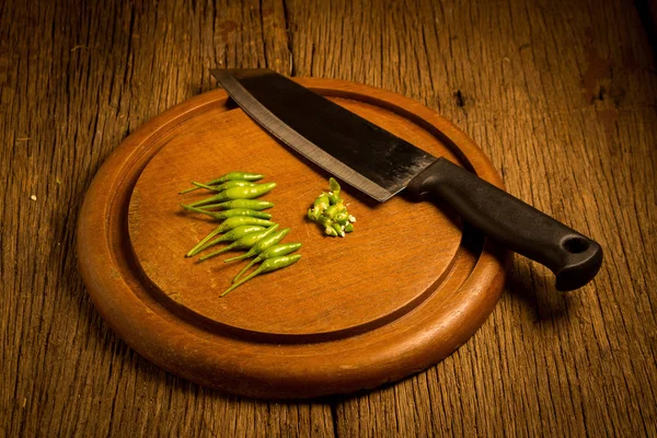 Round wood Chopping cutting board. chili peppers green and red.