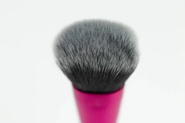 Selective focus on purple clean professional makeup brush isolated on white. Concept beauty.