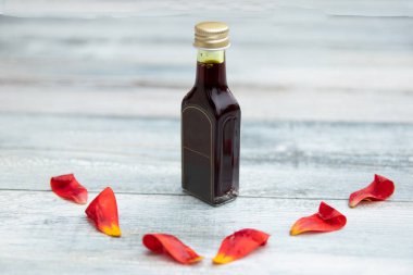 Şişe ile petrol ve taze lale pedalların üzerinde parlak rustik ahşap masa metin kopya alanı ile. 