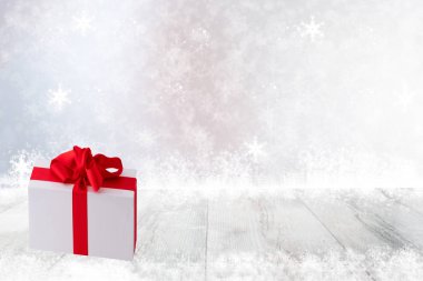 Noel ve mutlu yeni yıl dekorasyon arka plan. Noel hediye kutusu parlak masa üstü ve soyut şenlikli beyaz kış arka plan üzerinde kar taneleri. Ürün görüntü montaj şablonu. Kart kavramı.