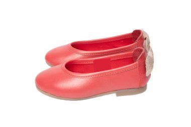 Kırmızı ayakkabılar. Beyaz bir arka plan üzerinde izole bir altın yay ayakkabılarla kırmızı kız closeup. Modaya uygun ayakkabı.