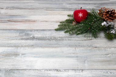 Noel ve mutlu yeni yıl dekorasyon arka plan. Rustik ahşap arka plan üzerinde kırmızı bir elma ve köknar koniler ile kompozisyon parlak Noel ağaç dalları. Üstten görünüm kopya alanı.