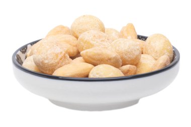 Fındık arka plan. Kavrulmuş ve tuzlu macadamias ve badem fındık seramik kase beyaz bir arka plan üzerinde izole yakın çekim. Gurme somun macadamias ile karıştırın. Makro.