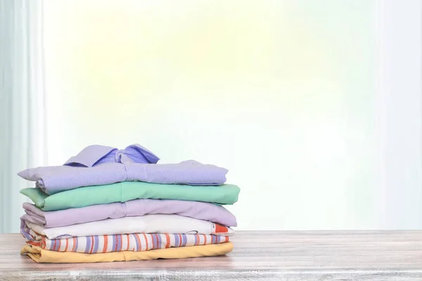 Stapel kleurrijke kleding. Stapel gevouwen katoenen shirts op een heldere — Stockfoto