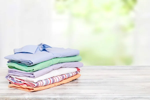 Stapel kleurrijke kleding. Stapel gevouwen katoenen shirts op een heldere — Stockfoto