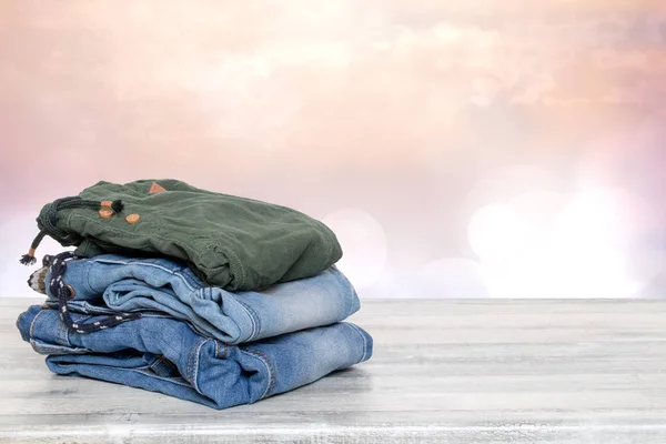 Stapel jeans. Close-up van een stapel kleurrijke denim broek op een b — Stockfoto