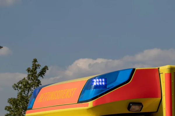 Blue flashing lights. Close-up of blue warning signals placed on the roof in a fire truck with the German inscription RETTUNGSDIENST translated into English AMBULANCE SERVICE