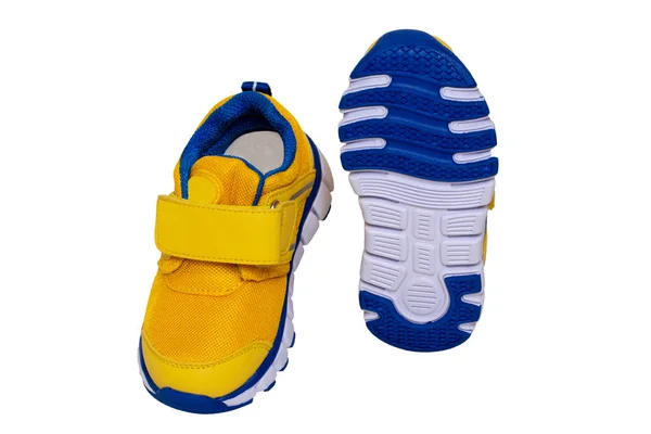 Kinderschuhmode. Großaufnahme eines gelb-blauen Kinderturnschuhs oder Sportschuhen isoliert auf weißem Hintergrund. Elegante und trendige Schuhe für Mädchen. Makro. — Stockfoto