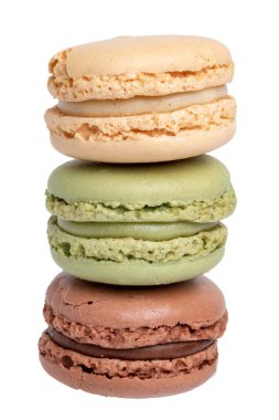 Pastalar, tatlılar ve tatlılar. Sarı Fransız vanilyalı kurabiyeye yakın plan, yeşil şam fıstıklı badem kurabiyesi ve beyaz arka planda izole edilmiş kahverengi çikolatalı kurabiye. Makro fotoğraf.