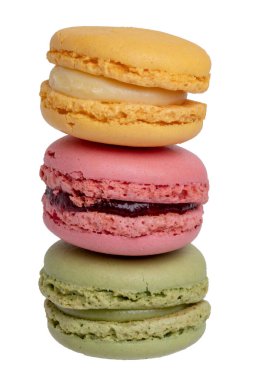 Pastalar, tatlılar ve tatlılar. Sarı Fransız limonlu badem kurabiyesi, kırmızı ahududulu makarna ve beyaz arka planda izole edilmiş yeşil şam fıstıklı badem kurabiyesi. Makro fotoğraf.