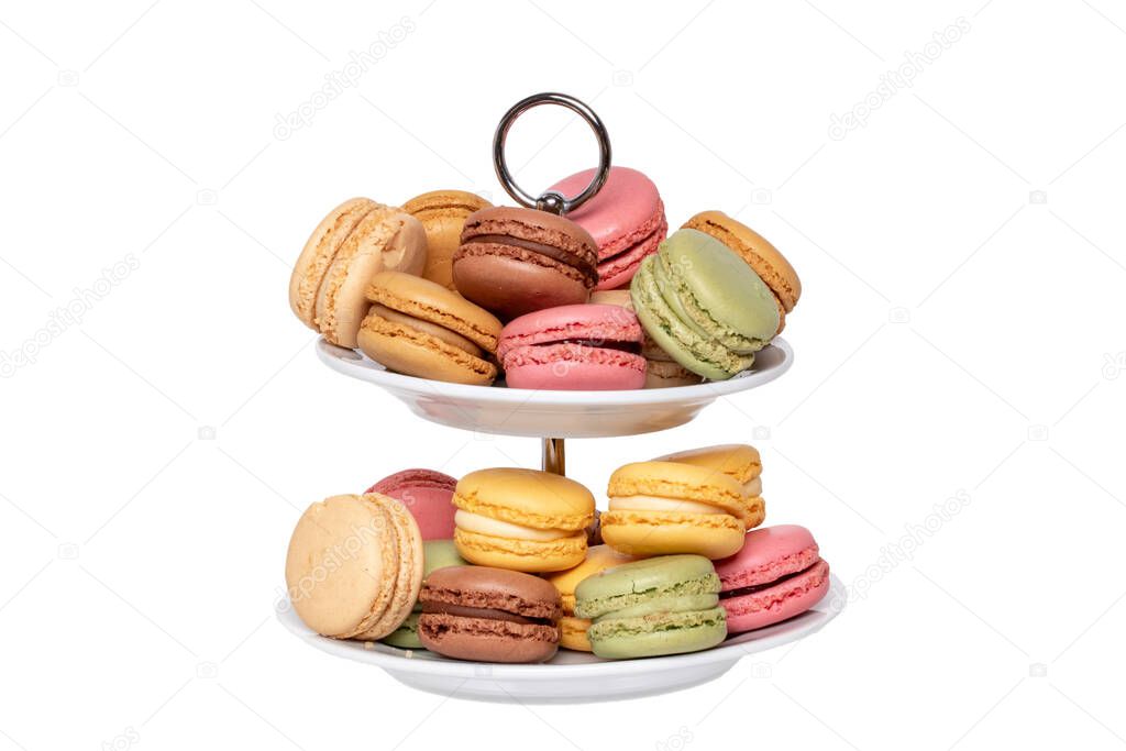 Macaron isolated. Close-up of colourful French macaroons on a two-storey etagere isolated on a white background. Pastries, desserts and sweets. Macro.