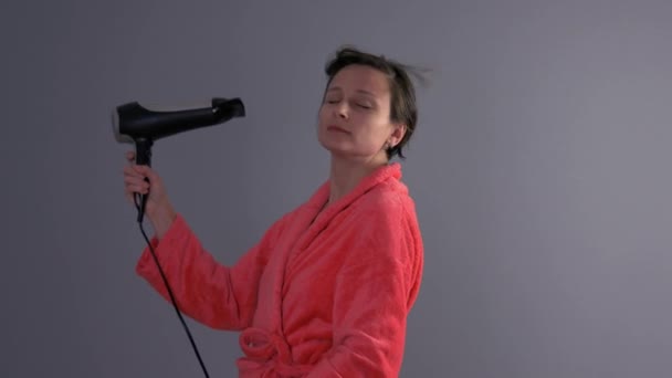 Woman drying hair with hairdryer — Stock Video