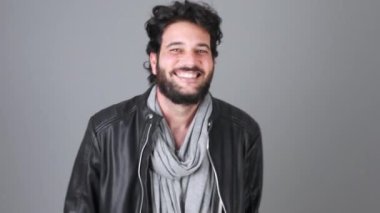 Genç Yetişkin sakallı adam eğlenceli olan gri bir arka plan üzerinde dans