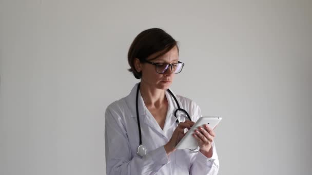 Женщина-врач за планшетным компьютером. Здравоохранение, страхование и медицина — стоковое видео