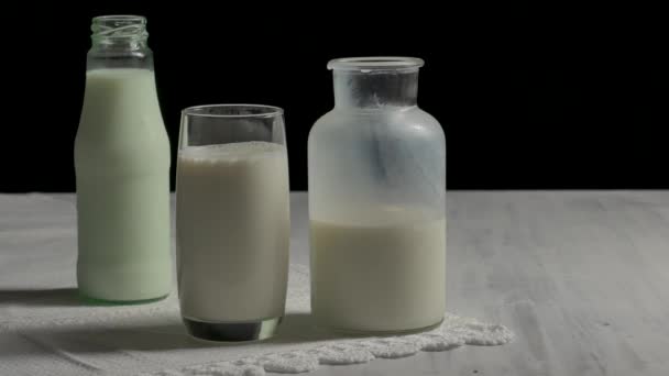 Glas Milch und Flasche Milch auf dem Holztisch. — Stockvideo