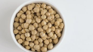 Beyaz bir arka plan üzerinde dönen çiğ nohut fasulye.