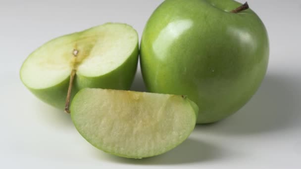 Manzana verde giratoria sobre fondo blanco — Vídeo de stock