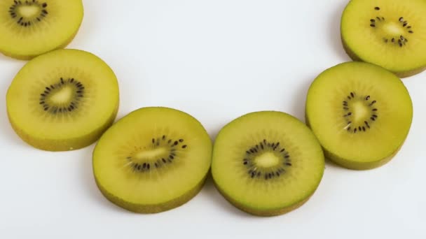 Rebanadas de fruta Kiwi girando sobre fondo blanco — Vídeos de Stock