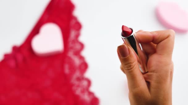 Primer plano de las manos de la mujer sosteniendo tubo de lápiz labial rojo abierto . — Vídeo de stock