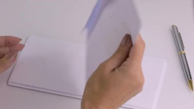 Belge içeren bir zarfı kapatan eller. Yukarıdan üstten görünüm.